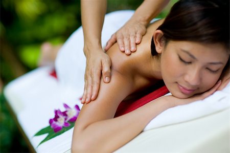 eastwestimaging (artist) - A young woman having massage outside in tropical garden Fotografie stock - Microstock e Abbonamento, Codice: 400-04116464