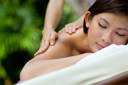 eastwestimaging (artist) - A young woman having massage outside in tropical garden Fotografie stock - Microstock e Abbonamento, Codice: 400-04116462