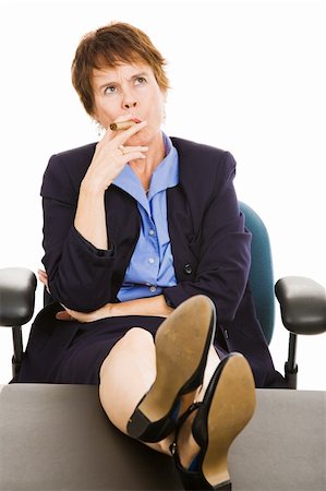 female executives cigars - Mature businesswoman smoking a cigar and thinking with feet on her desk.  Isolated on white. Stock Photo - Budget Royalty-Free & Subscription, Code: 400-04116783