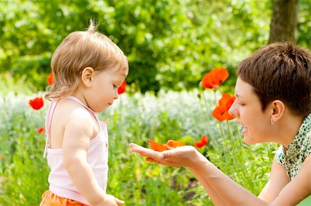 Mother showing poppy flower to her daughter Foto de stock - Super Valor sin royalties y Suscripción, Código: 400-04117722