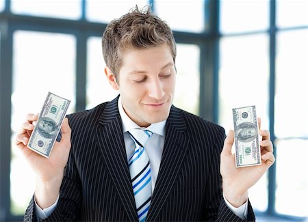 simsearch:400-05718322,k - Young businessman holding dollars in office Fotografie stock - Microstock e Abbonamento, Codice: 400-04118207