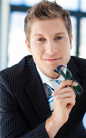 simsearch:400-07680948,k - Attractive businessman looking to the camera holding glasses Stock Photo - Budget Royalty-Free & Subscription, Code: 400-04118236