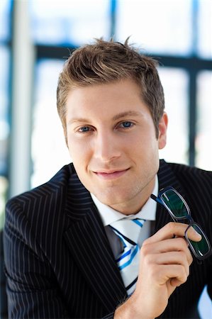 simsearch:400-07680948,k - Attractive businessman smiling at the camera holding glasses Stock Photo - Budget Royalty-Free & Subscription, Code: 400-04118237