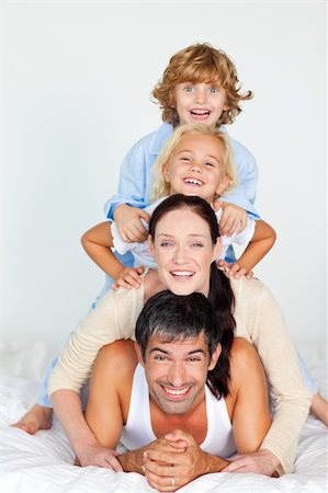 simsearch:400-04878558,k - Parents and children playing together in bed Stock Photo - Budget Royalty-Free & Subscription, Code: 400-04118324