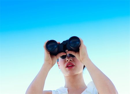 simsearch:400-04632747,k - Businesswoman looking through binoculars against blue sky Fotografie stock - Microstock e Abbonamento, Codice: 400-04118387