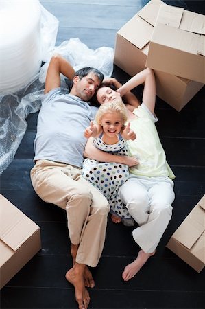 Parents and daughter on the floor of their new house with thumbs up Stock Photo - Budget Royalty-Free & Subscription, Code: 400-04118382