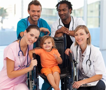 doctor speaking to young patient - Group of doctors with a baby in a wheelchair smiling at the camera Stock Photo - Budget Royalty-Free & Subscription, Code: 400-04118496