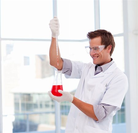 simsearch:400-07091851,k - Smiling young scientist examinig a test-tube Stock Photo - Budget Royalty-Free & Subscription, Code: 400-04118498