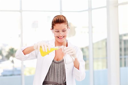 simsearch:6109-07497816,k - Smiling female scientist examinig a test-tube in a laboratory Fotografie stock - Microstock e Abbonamento, Codice: 400-04118505