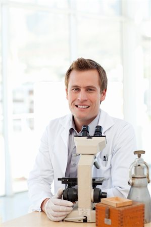 simsearch:400-05218769,k - Male scientist looking at a slide under a microscope in a laboratory Stock Photo - Budget Royalty-Free & Subscription, Code: 400-04118508