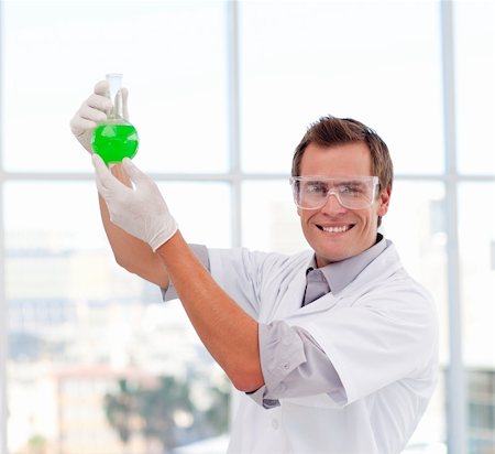 simsearch:400-06078063,k - Scientist examining a test-tube in a laboratory smiling at the camera Stock Photo - Budget Royalty-Free & Subscription, Code: 400-04118515