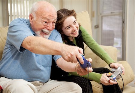 Grandfather enjoys playing video games with his teenage granddaughter. Stock Photo - Budget Royalty-Free & Subscription, Code: 400-04118528