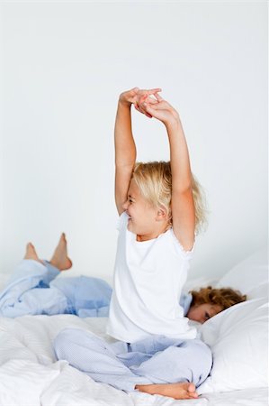 simsearch:400-04206266,k - Blonde girl stretching in bed after sleeping Stockbilder - Microstock & Abonnement, Bildnummer: 400-04118521