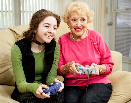 Teen girl has fun playing video games with her grandmother. Stock Photo - Budget Royalty-Free & Subscription, Code: 400-04118533