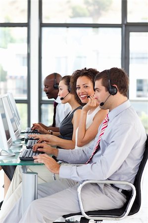 simsearch:400-04119293,k - Smiling African-American businesswoman working in a call center with her colleagues Fotografie stock - Microstock e Abbonamento, Codice: 400-04119297