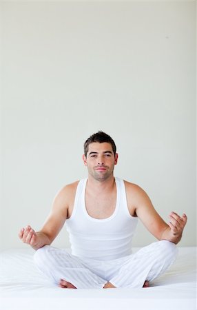 Attractive young man doing exercises in bed Stock Photo - Budget Royalty-Free & Subscription, Code: 400-04119657