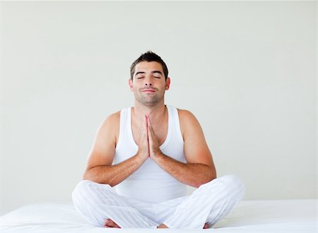 Attractive young man practicing yoga in bed Stock Photo - Budget Royalty-Free & Subscription, Code: 400-04119659