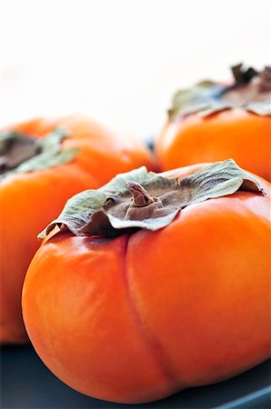 diospyros - Orange whole ripe persimmon fruit on a plate Stock Photo - Budget Royalty-Free & Subscription, Code: 400-04111307