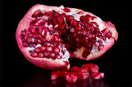 A piece of open pomegranate with seeds isolated on black background Stock Photo - Budget Royalty-Free & Subscription, Code: 400-04111319