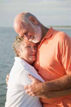 simsearch:400-05234340,k - Senior couple in a loving embrace with the ocean in the background. Stock Photo - Budget Royalty-Free & Subscription, Code: 400-04111504