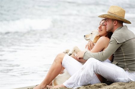 attractive romantic couple with a dog sitting on the beach Stock Photo - Budget Royalty-Free & Subscription, Code: 400-04111742