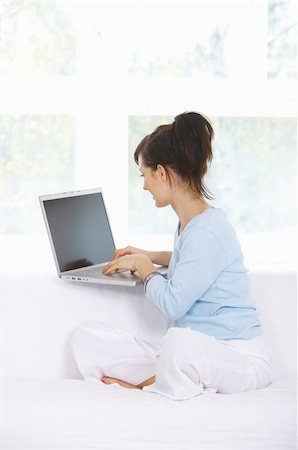 Young woman is on couch and working on laptop Stock Photo - Budget Royalty-Free & Subscription, Code: 400-04111940