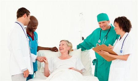 Young team of Doctors at  a patients bedside Stock Photo - Budget Royalty-Free & Subscription, Code: 400-04112112
