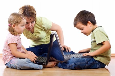 daycare on floor - Kids using laptops supervised by a woman - isolated Stock Photo - Budget Royalty-Free & Subscription, Code: 400-04112492