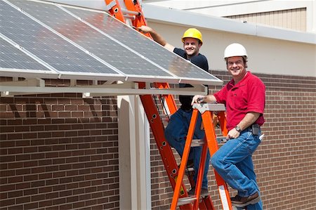 simsearch:400-04056225,k - Happy electricians employed to install energy efficient solar panels in the new green economy. Stockbilder - Microstock & Abonnement, Bildnummer: 400-04112821