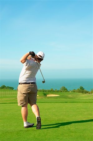 simsearch:400-04942072,k - Young male golfer hitting the ball from the green on a beautiful summer day Foto de stock - Royalty-Free Super Valor e Assinatura, Número: 400-04113687