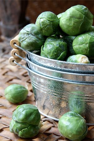 A bunch of brussels sprouts in a stack of three small tin buckets, with a few laying on a leather surface. Stock Photo - Budget Royalty-Free & Subscription, Code: 400-04113779