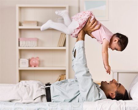 A father is holding his young daughter in the air above him.  They are smiling at each other.  Square framed shot. Stock Photo - Budget Royalty-Free & Subscription, Code: 400-04124074