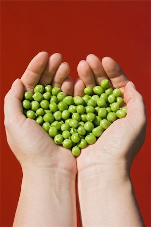 Woman's hands holding green peas on red background Stock Photo - Budget Royalty-Free & Subscription, Code: 400-04124533