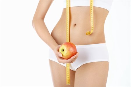 Close up of a harmonous female stomach with an apple and the measuring tape, isolated Stock Photo - Budget Royalty-Free & Subscription, Code: 400-04124550
