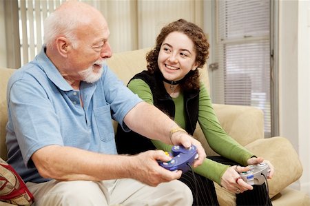 Grandfather spends quality time with his granddaughter playing video games. Stock Photo - Budget Royalty-Free & Subscription, Code: 400-04124567