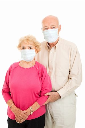 Worried senior couple wearing surgical masks to protect against flu epidemic.  Isolated. Stock Photo - Budget Royalty-Free & Subscription, Code: 400-04124575
