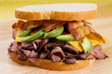 sandwich with avocado - Roast beef sandwich with cheddar cheese, sliced avocado, and bacon strips. Stock Photo - Budget Royalty-Free & Subscription, Code: 400-04124764