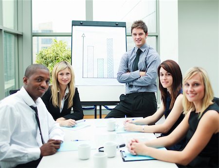 simsearch:400-05155599,k - Handsome businessman in a meeting with his colleagues smiling at the camera Stock Photo - Budget Royalty-Free & Subscription, Code: 400-04125249