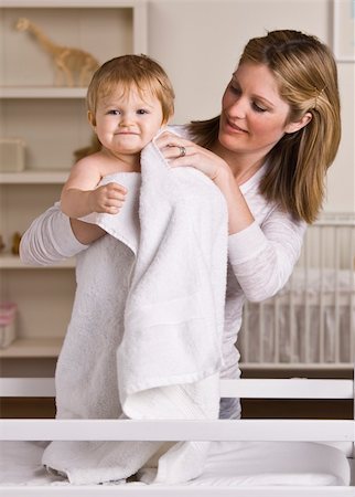 A beautiful young mother drying off her baby with a towel.  They have slight smiles on their faces.  Vertically framed shot. Stock Photo - Budget Royalty-Free & Subscription, Code: 400-04126293