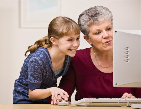 A senior woman and a young girl share a mouse as they use a computer together. Stock Photo - Budget Royalty-Free & Subscription, Code: 400-04126320