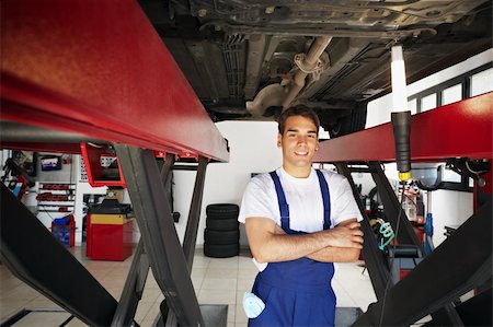 portrait young man mechanic - portrait of mechanic standing under car with arms folded. Copy space Stock Photo - Budget Royalty-Free & Subscription, Code: 400-04126655