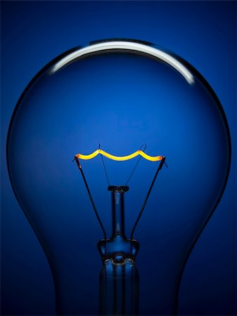 simsearch:400-04303624,k - Hautnah auf eine transparente Glühbirne über einen blauen Hintergrund. Wolframkathode glühend. Stockbilder - Microstock & Abonnement, Bildnummer: 400-04127327