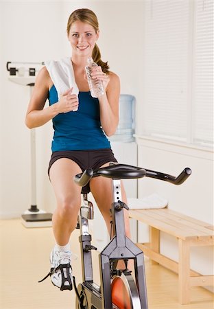 Woman riding stationary bicycle in health club Stock Photo - Budget Royalty-Free & Subscription, Code: 400-04128730