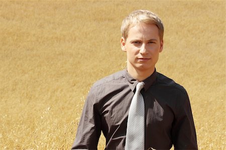 simsearch:400-04064843,k - Young modern farmer in suit standing in field of oats Fotografie stock - Microstock e Abbonamento, Codice: 400-04129105