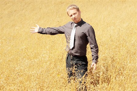 simsearch:400-04064843,k - Young modern farmer in suit standing in field of oats Fotografie stock - Microstock e Abbonamento, Codice: 400-04129101