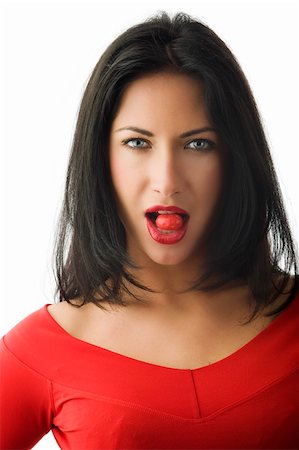 portrait of beautiful brunette with red lips red top and a red candy between teeth Stock Photo - Budget Royalty-Free & Subscription, Code: 400-04129511