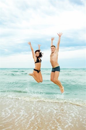 Happy young couple jumping in the sea Stock Photo - Budget Royalty-Free & Subscription, Code: 400-04129920