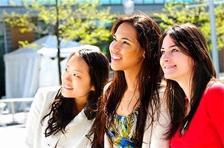 Three diverse young girlfriends smiling into camera Stock Photo - Budget Royalty-Free & Subscription, Code: 400-04120267
