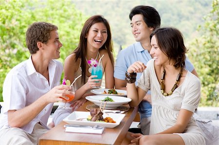 eastwestimaging (artist) - Four young adults enjoying a meal together on vacation Fotografie stock - Microstock e Abbonamento, Codice: 400-04120275