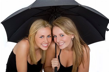 sharing umbrella - Studio shot of two beautiful young women sharing an umbrella Stock Photo - Budget Royalty-Free & Subscription, Code: 400-04120465